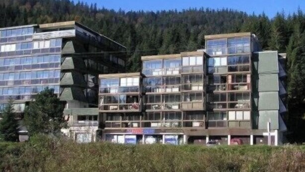 Un edificio de varios pisos con un diseño arquitectónico moderno, que cuenta con balcones y ventanas amplias.