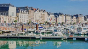 A marina with boats docked, surrounded by historic buildings with flags. - Charming house close to the beach and Mers les bains (Criel-sur-Mer)