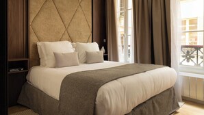 A neatly made bed with a headboard, a bedside table, and a window with curtains. - Elegant Apartment - 2br- 6P- Gare Saint Lazare (Paris)