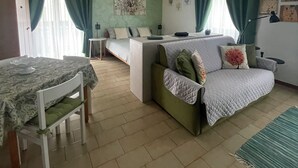Un salon confortable avec un canapé, une table à manger et un coin cuisine.