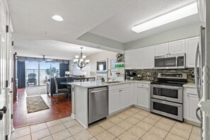 Una cocina moderna con armarios blancos, electrodomésticos de acero inoxidable y una isla central.