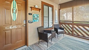 A wooden door with a surfboard decoration, a 'hello' sign, and a 'no dogs allowed' sign. - Heron Pointe E8 - Golf, Beach, Pool, & Hot Tub (Myrtle Beach)