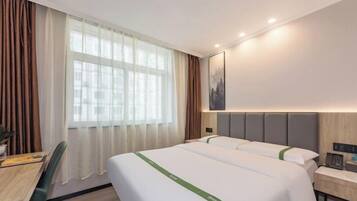 Une chambre d’hôtel avec deux lits, un bureau et une chaise.