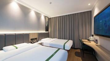 Une chambre d’hôtel avec deux lits, un bureau, une chaise, un téléviseur à écran plat et une grande fenêtre avec des rideaux.