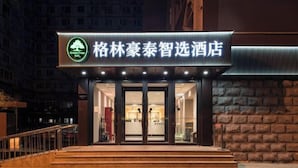 Entrada d'hotel amb un cartell que diu "GreenTree Inn" i "GreenTree Inn".