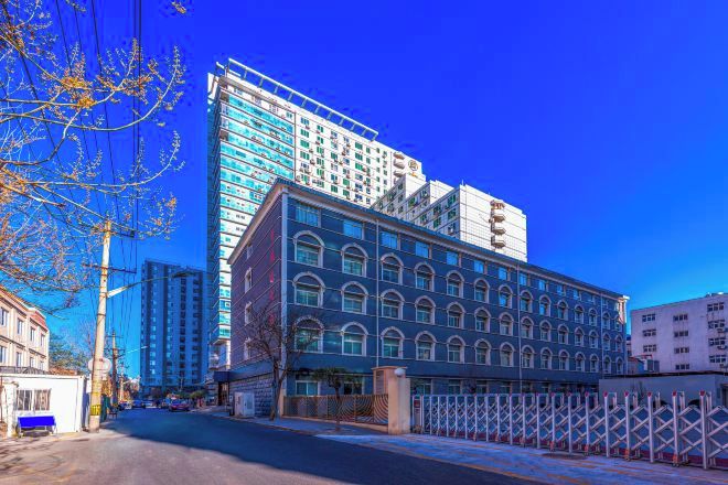 A multi-story building with a modern glass facade and a classic architectural style.