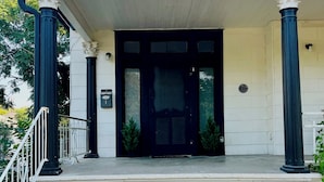 A building entrance with a black door, white columns, and a number '429' above the door.