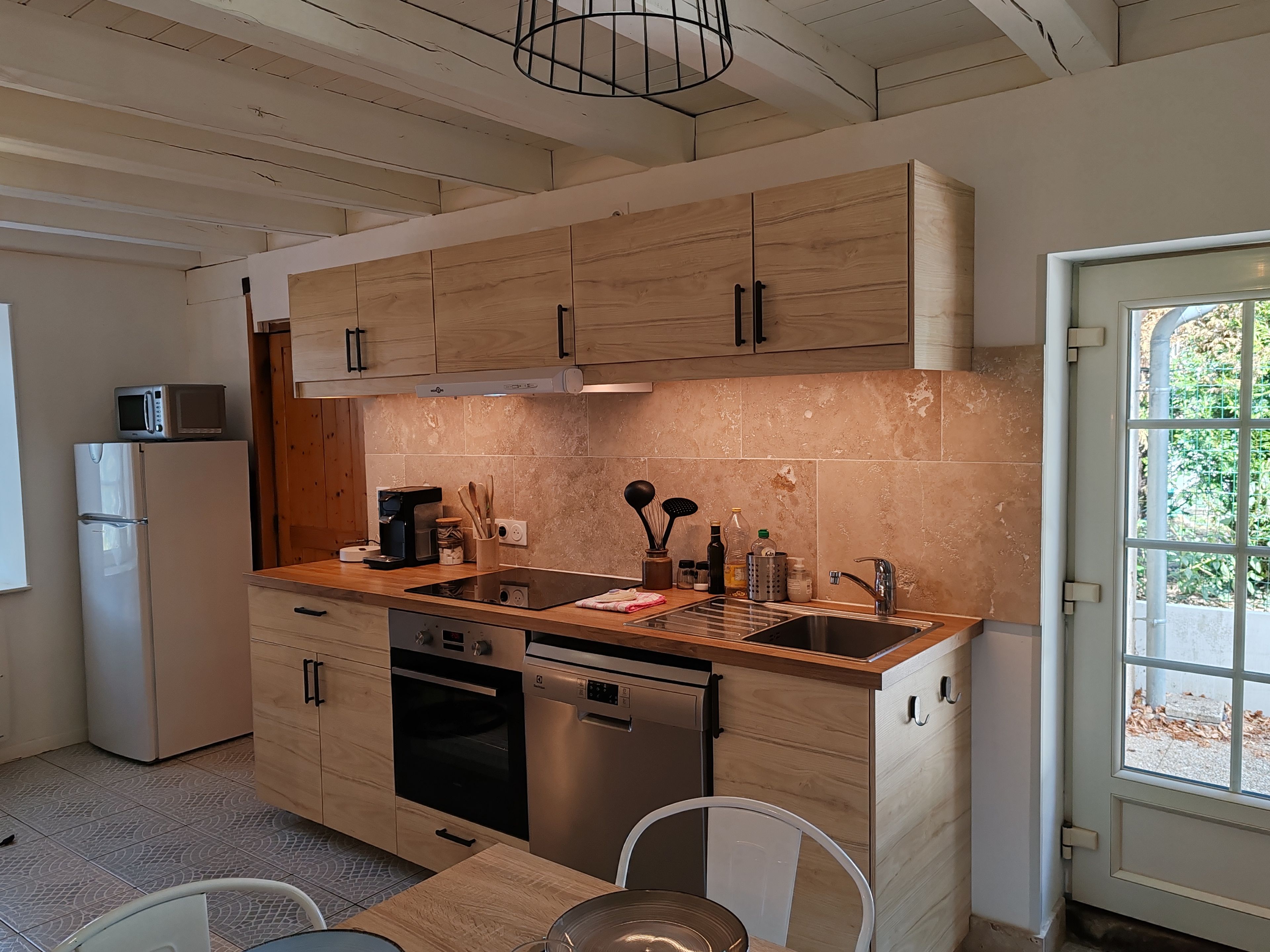 A modern kitchen with wooden cabinets, a stainless steel sink, and a built-in oven.