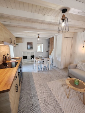 A spacious living area with a kitchen, dining table, and seating. - Cottage in Sully sur Loire (Sully-sur-Loire)