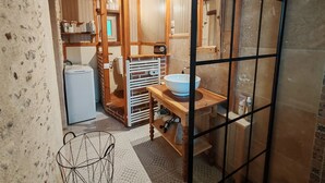 Une petite salle de bain avec un meuble-lavabo en bois, un lavabo blanc et un porte-serviettes.