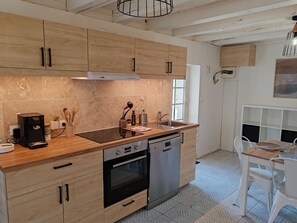 Una cocina moderna con armarios de madera, horno empotrado y lavavajillas.