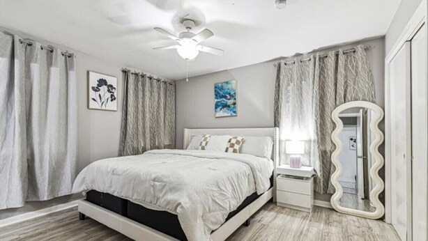 A bedroom with a bed, nightstands, a vanity with a mirror, a ceiling fan, and curtains. - Serene 3BR Luxe Easy Access to NRG & Galleria (Houston)