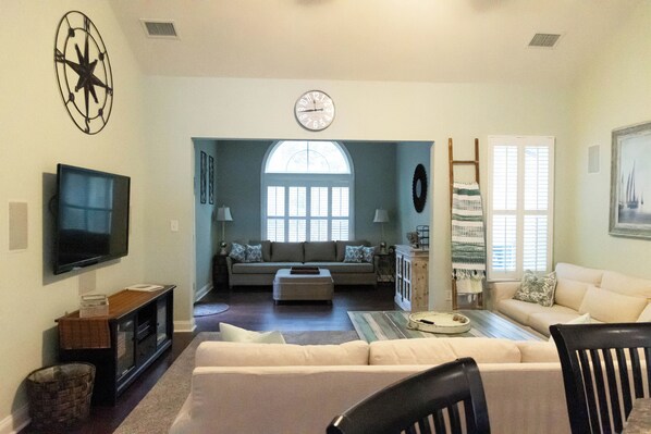 A living room with a television, sofas, and a large window. - Duplex in Forest Landing @Bethany Beach Sleeps 10+/3.5 baths-cul-de-sac lot (Frankford)