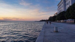 A waterfront promenade with a paved walkway, a row of buildings, and the sea in the background. - Charming 2-bedroom apartment with AC, WiFi in fantastic centre of the Zadar (Zadar)