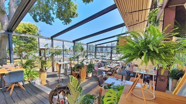 An outdoor dining area with tables and chairs, surrounded by potted plants and overlooking a cityscape. - Charming 2-bedroom apartment with AC, WiFi in fantastic centre of the Zadar (Zadar)