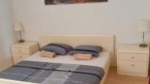 A bedroom with a bed, two bedside tables, and a wall-mounted painting. - Charming 2-bedroom apartment with AC, WiFi in fantastic centre of the Zadar (Zadar)