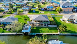 A residential area with houses, a dock, and a body of water. - Canalfront | Hot Tub | Boat Slip | Sleeps 10 (Crystal Beach)