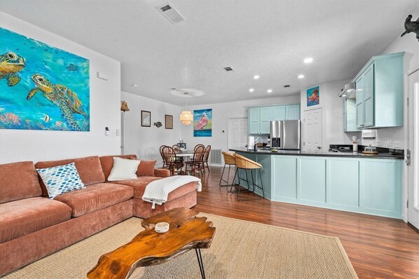 A modern living room with a sofa, coffee table, and artwork on the wall.