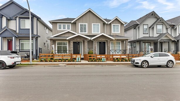 A row of townhouses with a central entrance, a driveway, and two parked cars. - Levida Living - Cozy 2 Bedroom Suite at the Heart of Langley (Langley)