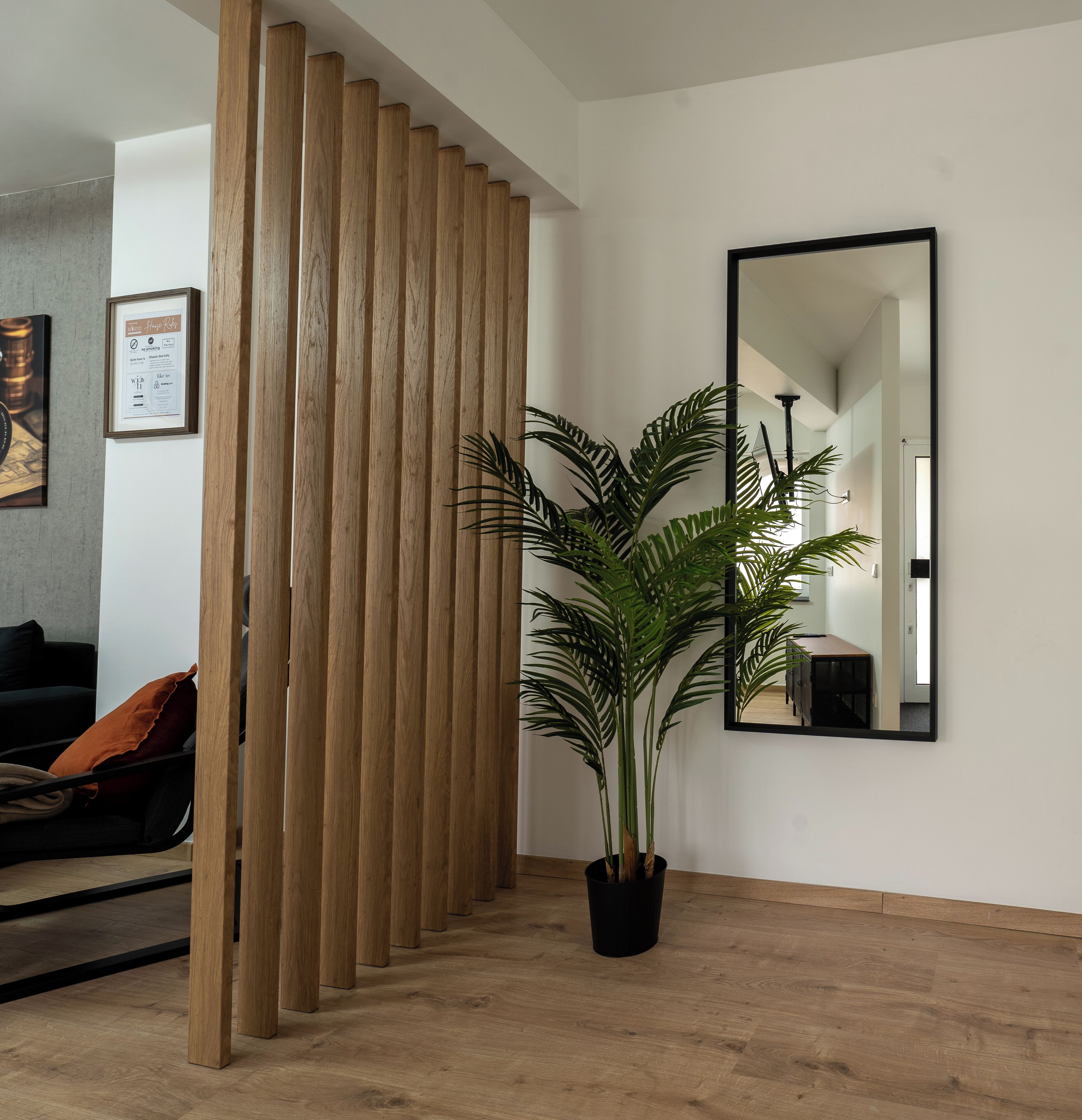 Ein Zimmer mit Holzwand, einem großen Spiegel und einem Blumentopf.