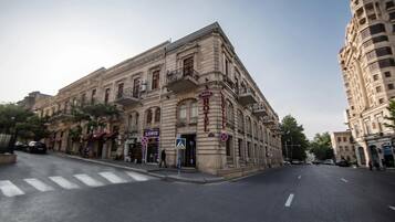 A historic building with a prominent "HOTEL" sign, a pedestrian crossing, and a "PASSAGE" sign.