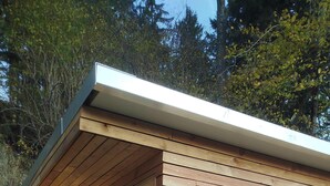 A wooden sauna with a bench and a bench seat, a glass door, and a wooden deck. - Vacation home with panoramic sauna, free e-bike rental & space for 6 people! (Sankt Gertraud)