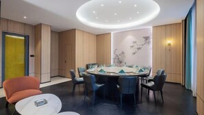 A modern conference room with a round table, chairs, and a unique ceiling light fixture. - Haiyi Fino Hotel (Jingmen)