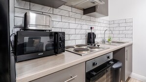 A modern kitchen with a built-in microwave, stove, and oven. - Roof Terrace | W/M | Smart TV | Free Parking (Old Swan)