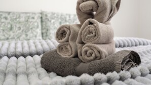 Una escultura de toalla doblada con forma de oso sobre una cama con textura.