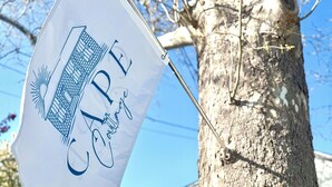 A flag with the text "CAPE" and "Orange" on a tree.