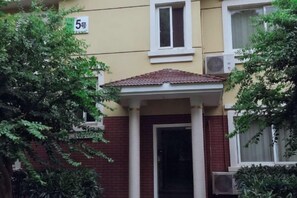 Ein Gebäude mit rotem Ziegeldach, einer weißen Tür und einem Balkon.