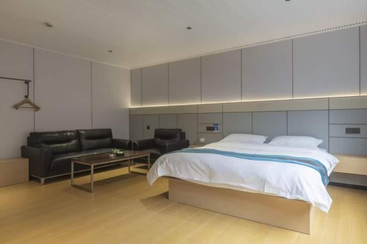 A modern bedroom with a bed, a sofa, and a coffee table.