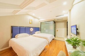 A hotel room with two beds, a desk with a computer, a TV, and a sliding door leading to a bathroom. - Wengang Xulong Hotel (Yiwu International Trade City Branch Yinhai No.1 District Branch) (Yiwu)