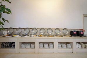 Montaje de bufé con múltiples estaciones de servicio, cada una con una variedad de alimentos y salsas.