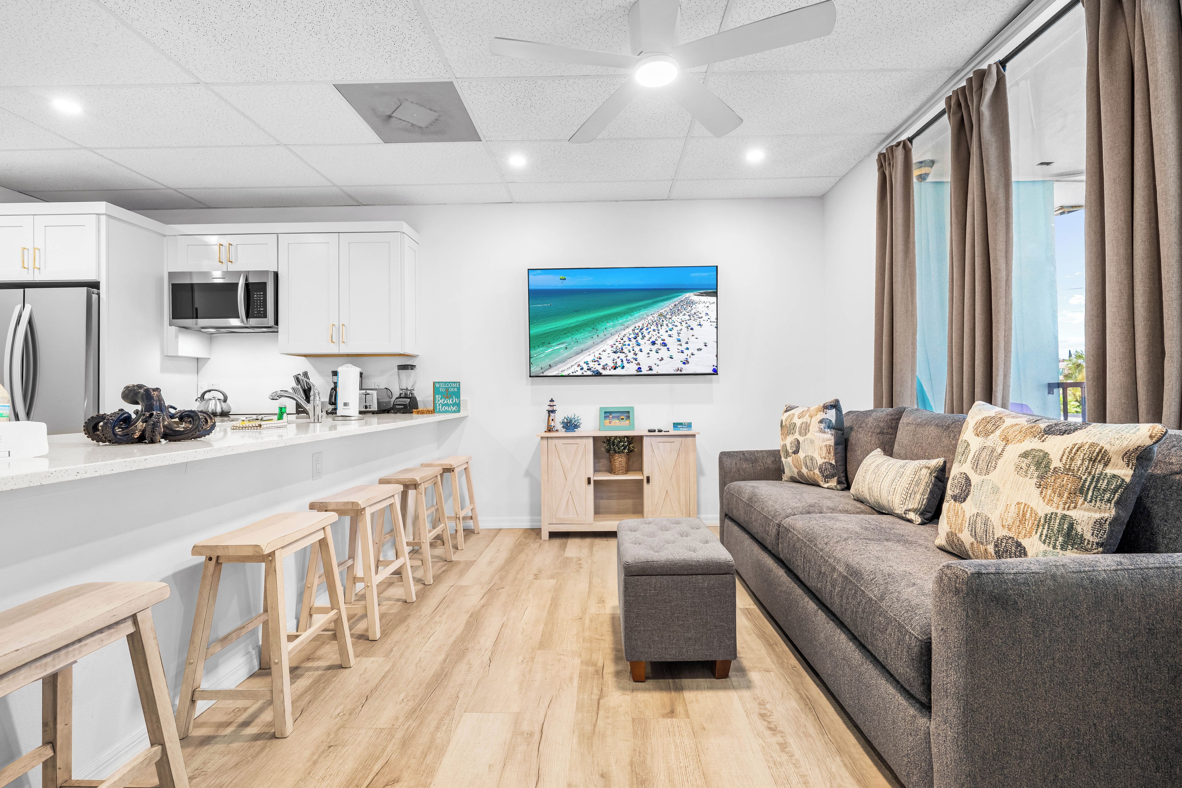 A modern kitchen with white cabinets and a stainless steel refrigerator.
