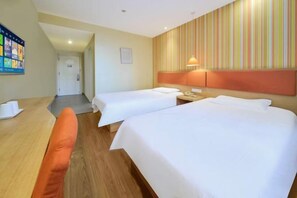 A hotel room with two beds, a desk, a chair, a wall-mounted lamp, and a door leading to another room. - Yuejia Hotel (Shanghai Qingpu District Sports Center Qingpu New City Metro Station Branch) (Shanghai)