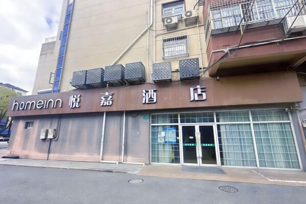 Um edifício com uma placa que diz 'homeinn' e caracteres japoneses, indicando que é um hotel.