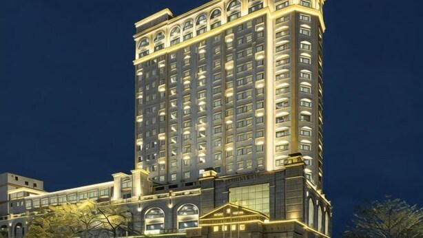 A high-rise hotel with multiple floors, large windows, and a prominent entrance.