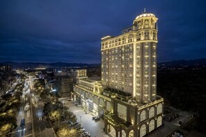 Un hotel de gran altura con una torre destacada, varios pisos y una fachada bien iluminada.