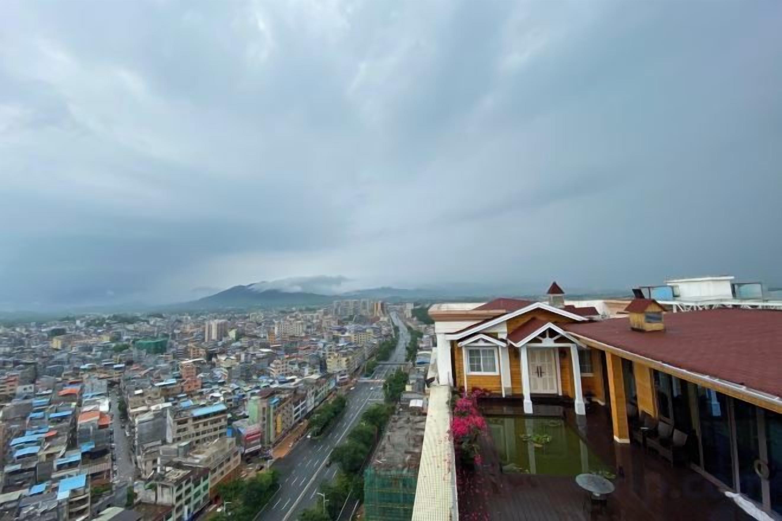 Un hotel moderno con vistas a un paisaje urbano y montañas a lo lejos.
