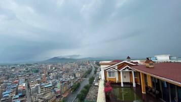 Un hotel moderno con vistas a un paisaje urbano y montañas a lo lejos.