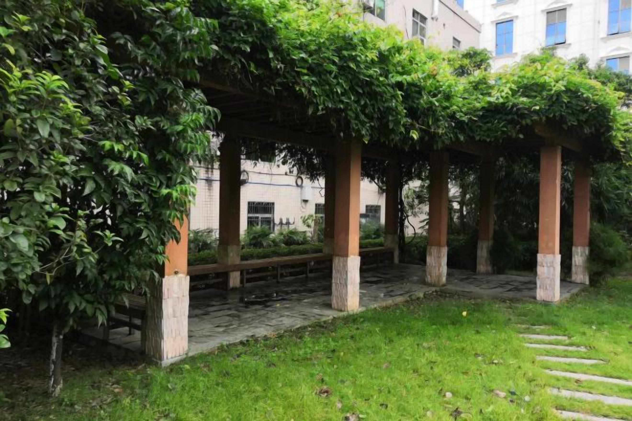Un espacio al aire libre cubierto con columnas de piedra y un banco de madera.