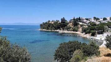 A coastal town with buildings on a hillside overlooking a calm sea.