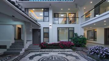 A modern two-story building with a central courtyard, large windows, and a patterned floor.