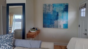 A living room with a sofa, a coffee table, and a painting on the wall. - Serene 3-bedroom waterfront newly renovated house, AC, Fast WiFi, Patio (White Marsh)