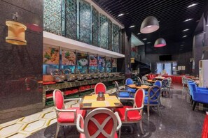 A restaurant interior with a long counter, multiple tables, and chairs. - Sunflower Hotel & Residence Serviced apartment (Shenzhen)