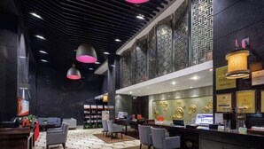 A modern hotel lobby with a reception desk, seating area, and decorative wall panels. - Sunflower Hotel & Residence Serviced apartment (Shenzhen)
