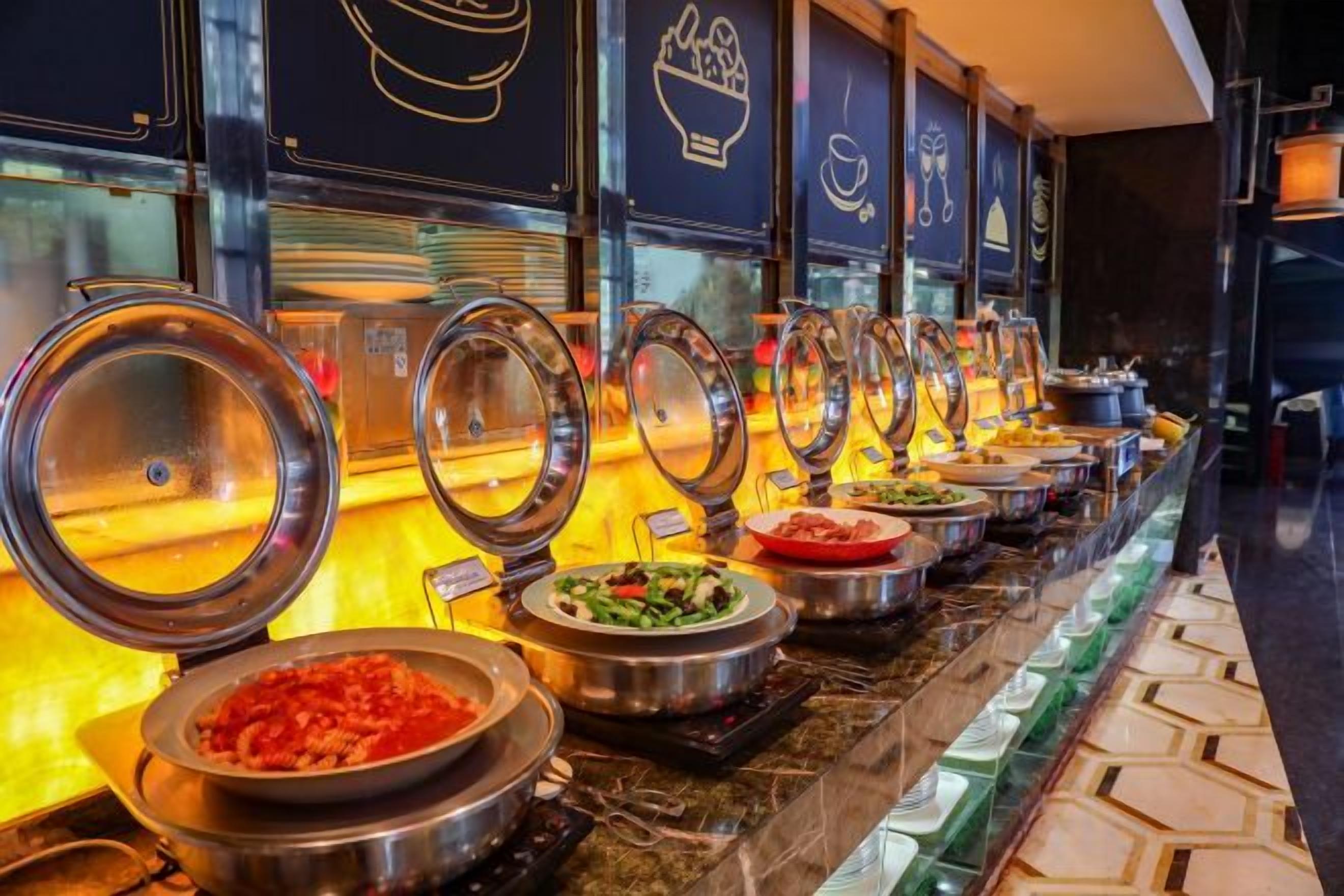Ein Buffet mit mehreren Servierstationen, jede mit einem abgedeckten Speisebehälter.