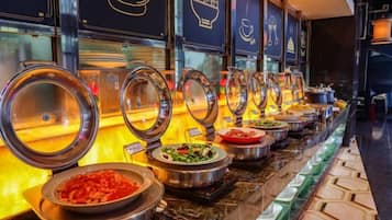 A buffet with multiple serving stations, each with a covered serving dish.