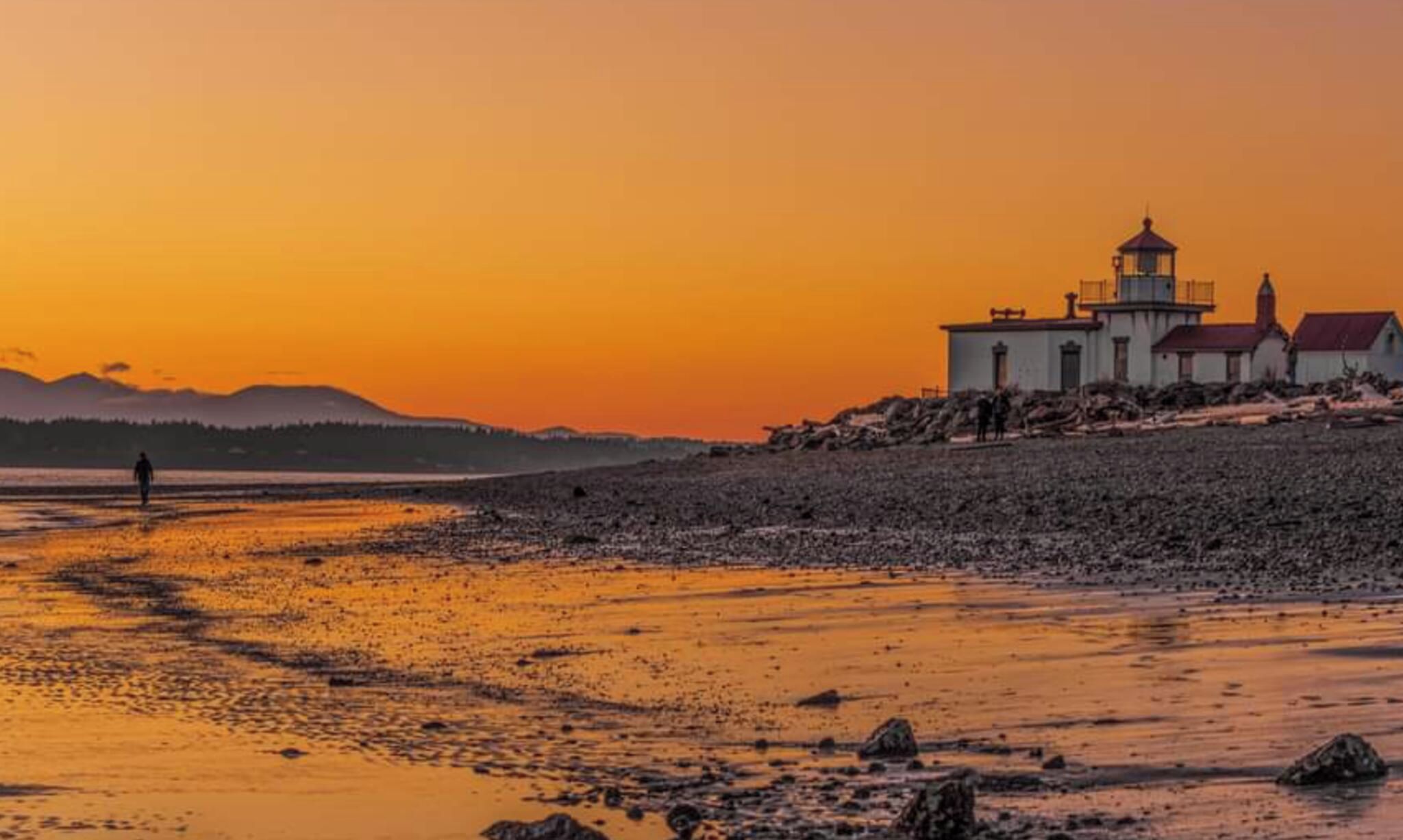 A coastal scene with a lighthouse and rocky terrain.